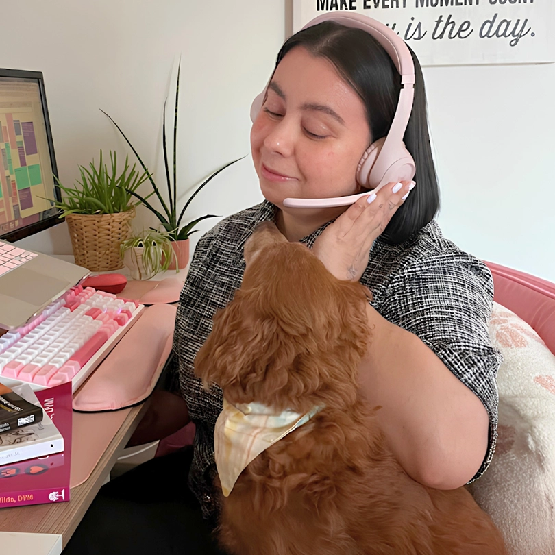 Rhianne Hallows on the phone with a dog in her lap